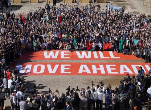 Hundreds of government and civil society supporters of the Paris Agreement pose together at the COP22 in Marrakech with a giant banner bearing the words 'We Will Move Ahead' to show their determination to move ahead with action against climate change in the wake of the US election.